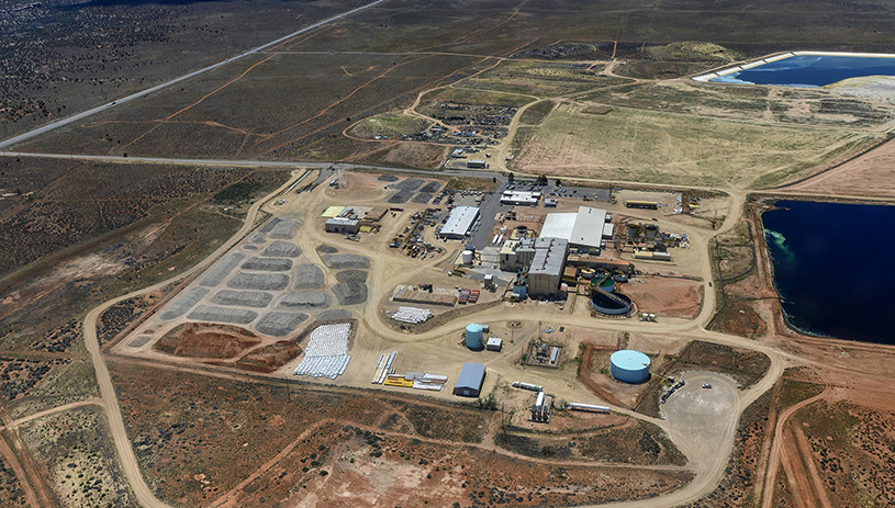 The ore pad at the White Mesa Mill on May 16, 2024. The suspected Japan Atomic Energy Agency containers can be seen at the bottom center of the photo, in a vertical white column beside the bright yellow area. Photo by Tim Peterson, flown by EcoFlight.