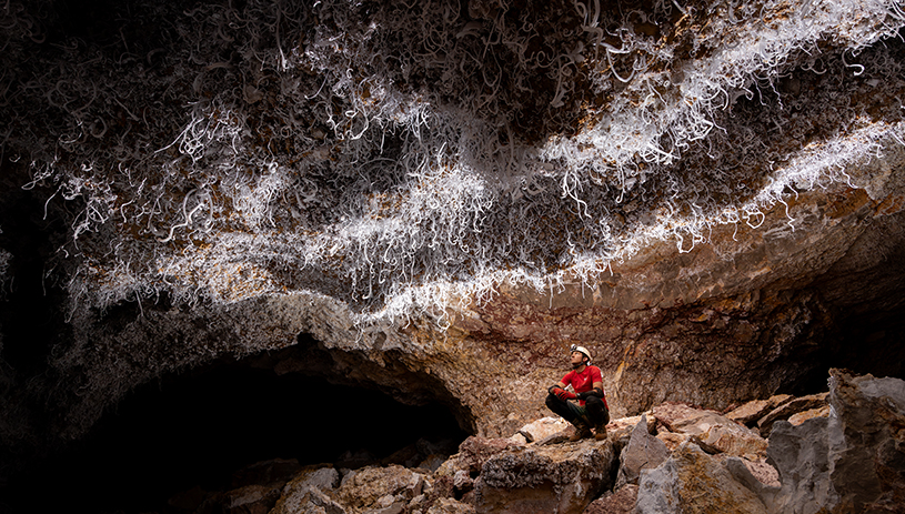 Andrew Chandler takes a break from mapping beneath a ceiling decorated with gypsum flowers. STEPHEN EGINOIRE