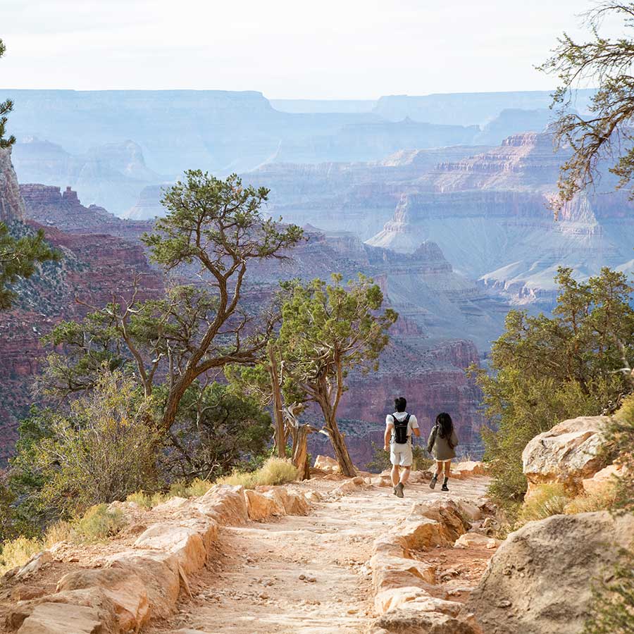 Two hikers head down the Bright Angel Trail in the Grand Canyon