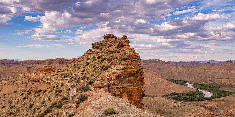 A figure walks a path along a ridge high above the White River, winding and lined with green, not far from the proposed Enefit oil shale project