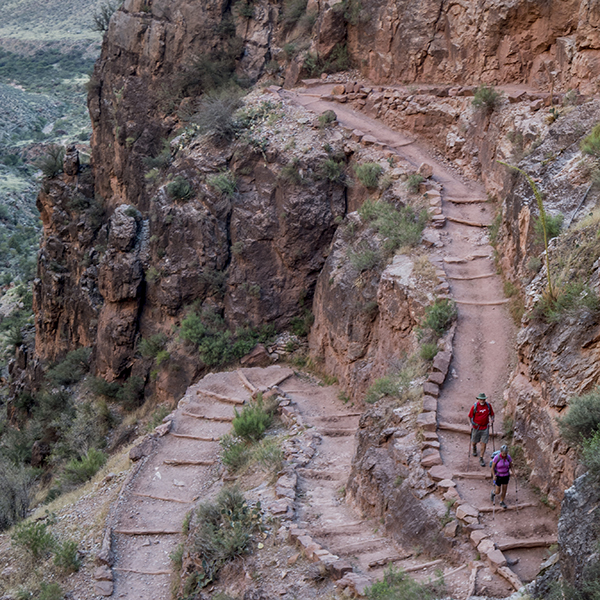 A view of two tight switchbacks on the bright angel trail with hikers making their way down the trai.