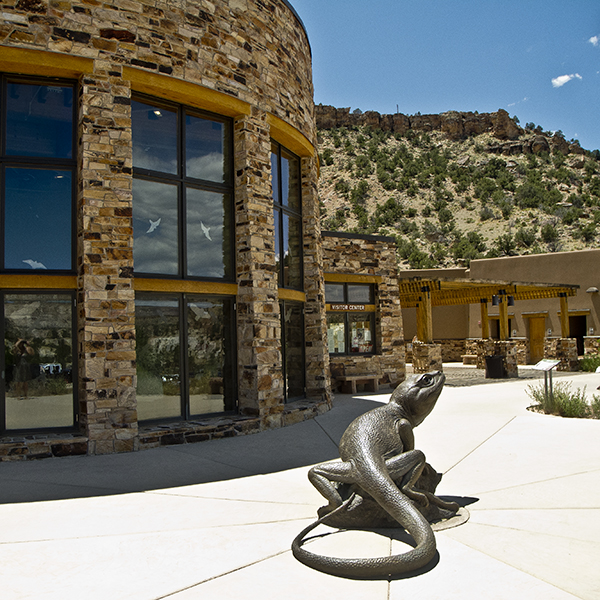 A metal lizard sculpture outside of the brick visitor center