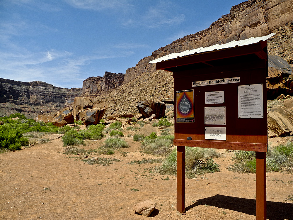 An informational board with cliffs in the background