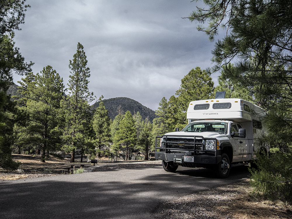 A camper truck with a cinder cone behind it