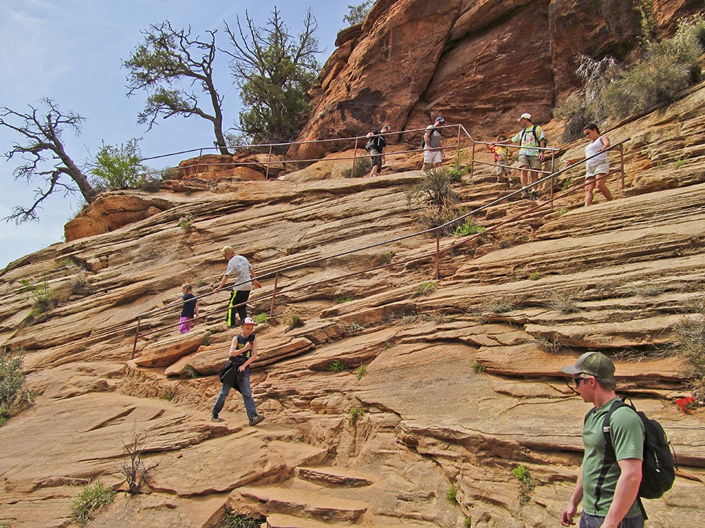 Hikers switchback up sandstone ledges