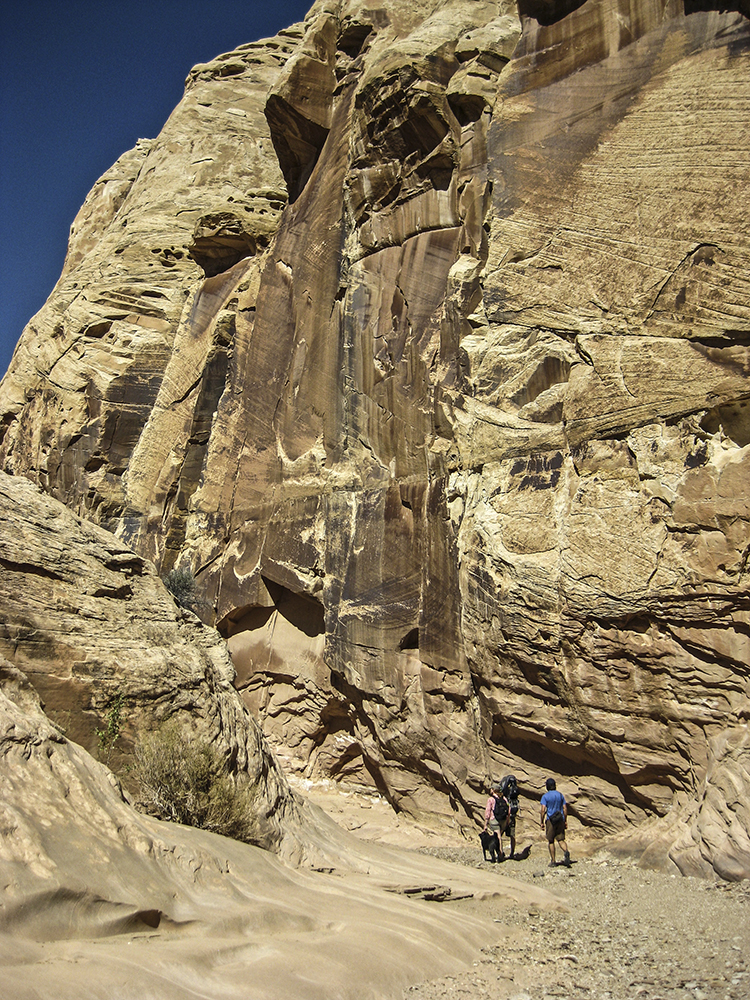 Two hikers at the base of the Chute Canyon walls