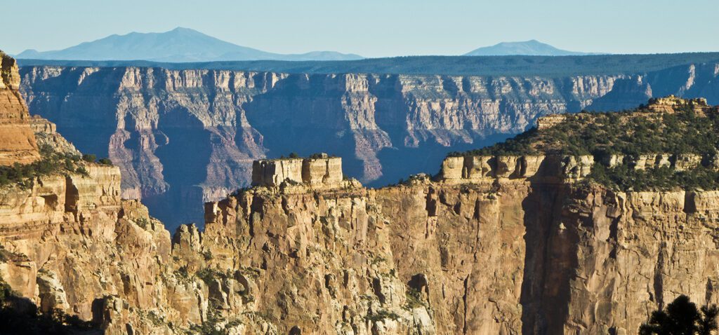 Cliffs of the north rim in the foreground, with the south rim cliffs in the middle ground, and the san Fransisco peaks in the far distance