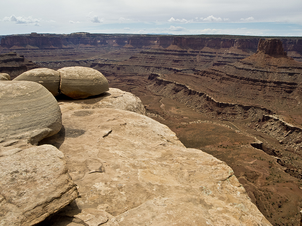 White sandstone boulders with orange cliffs below in Dead Horse