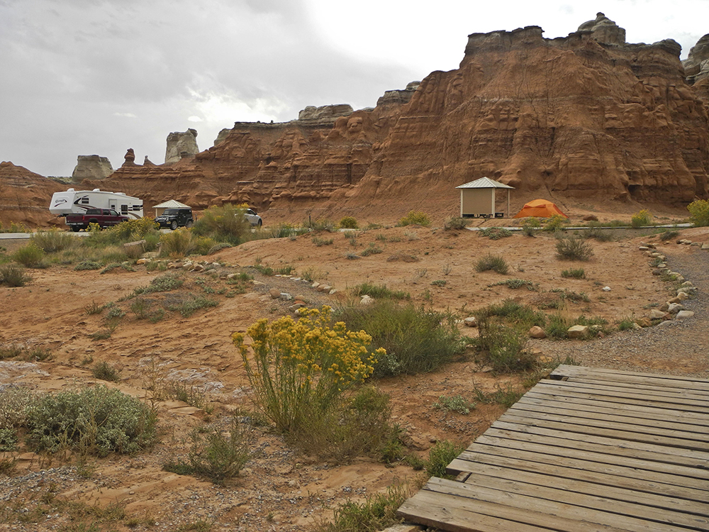 An RV and tent off in the distance at the campground