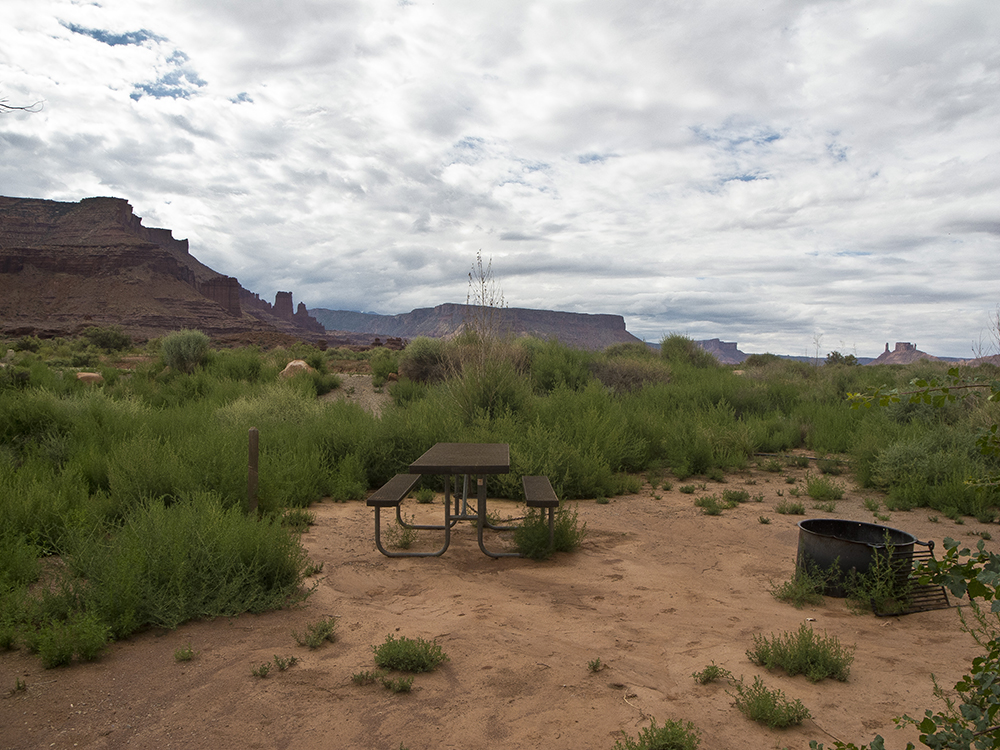 A picnic table and metal fire ring at an empty campsite in Hittle Bottom Campground