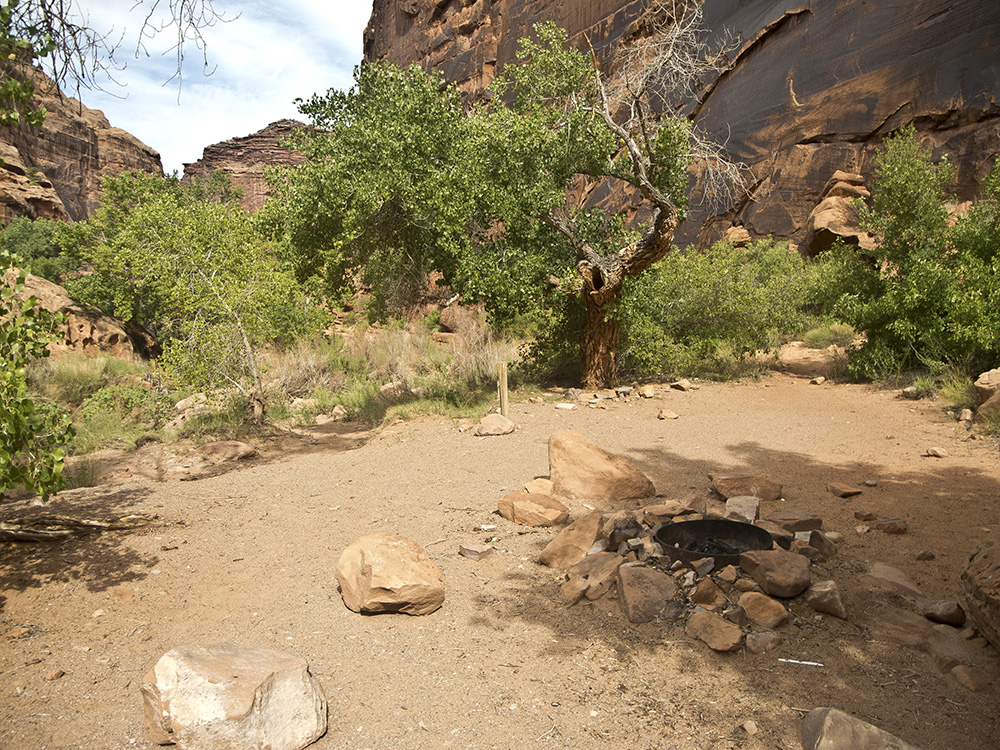 A rock fire ring in Hunter Canyon Campground with canyon walls in the background