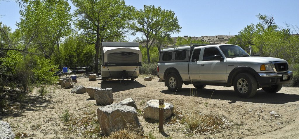 A pop up campper and a truck in a campsite