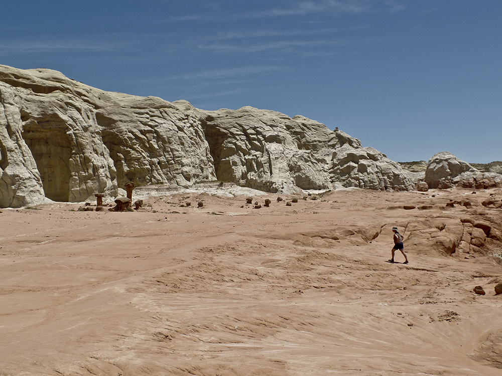 A woman in the distance walks across a slickrock bench