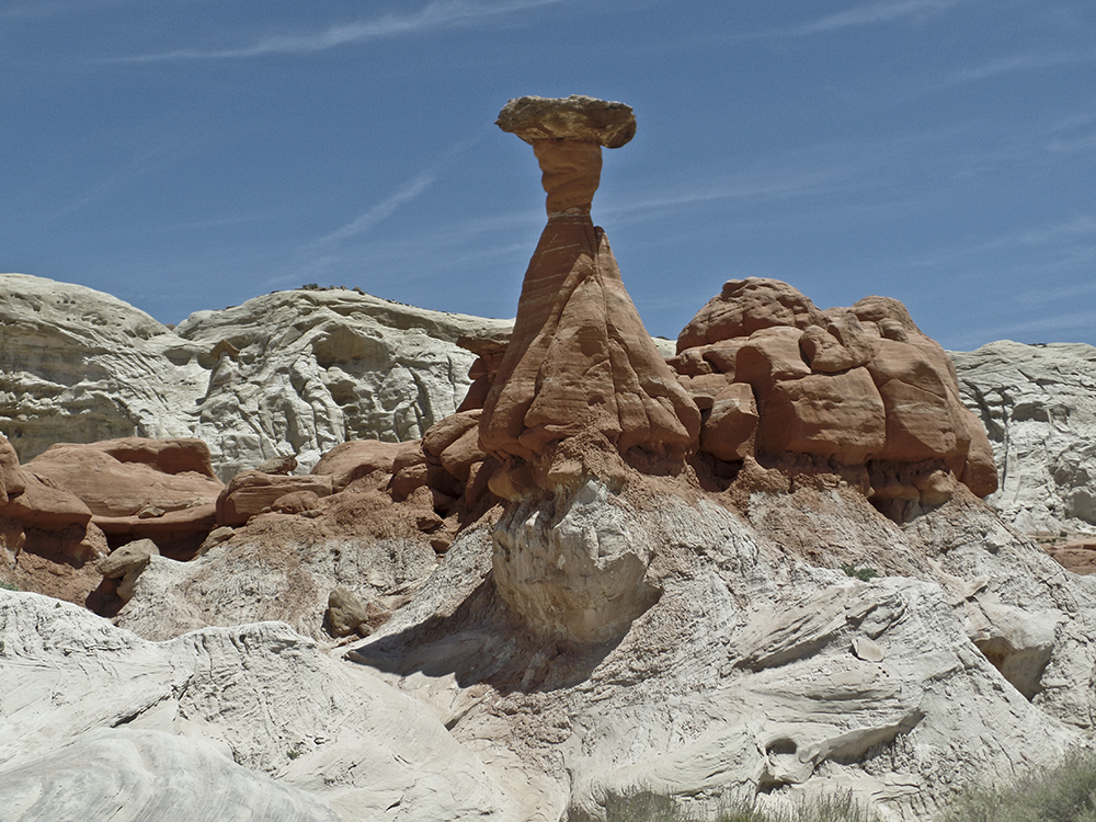 A view of an orange pillar with a flat rock capping the top