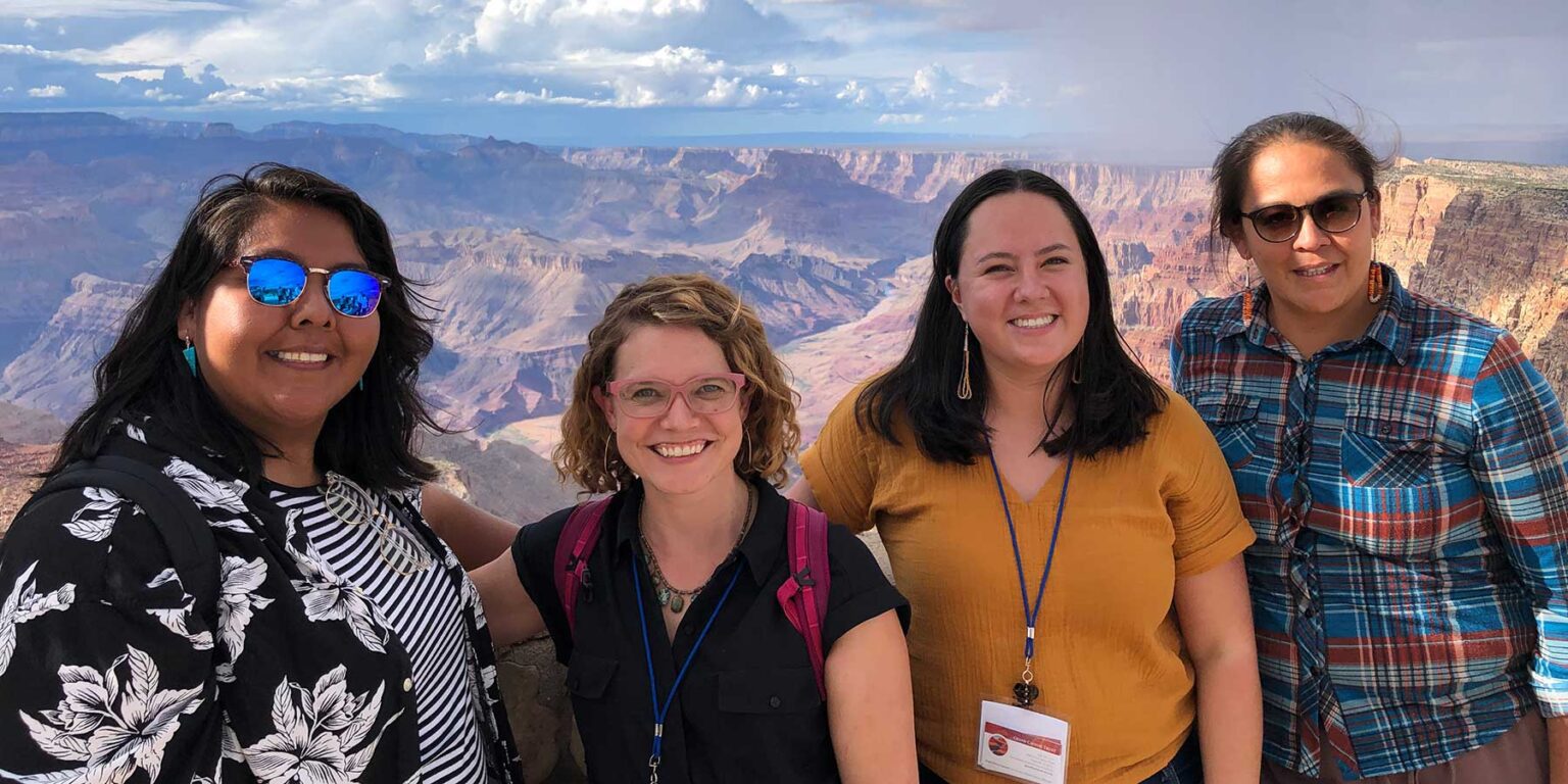 Four women employees of the Grand Canyon Trust pose on the rim of the Grand Canyon