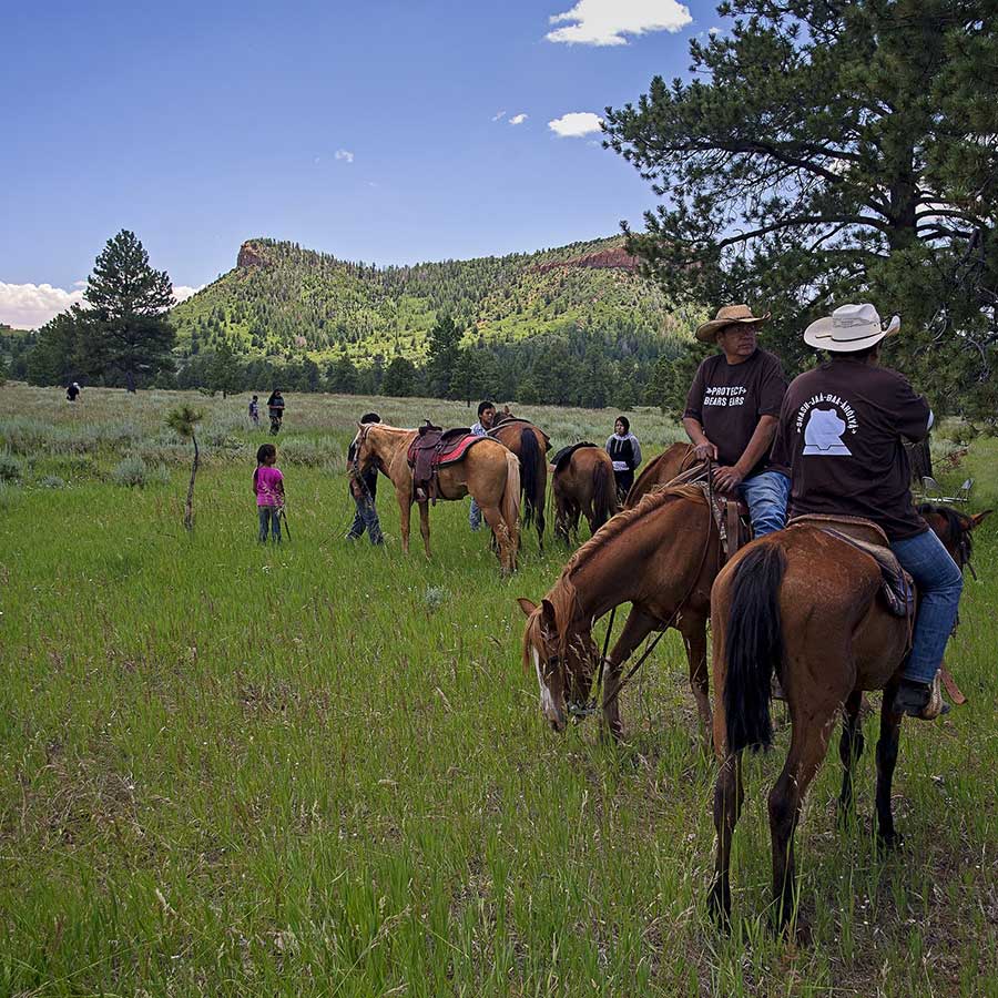 Men on horseback in protect Bears Ears t-shirts in a meadow near the Bears Ears buttes