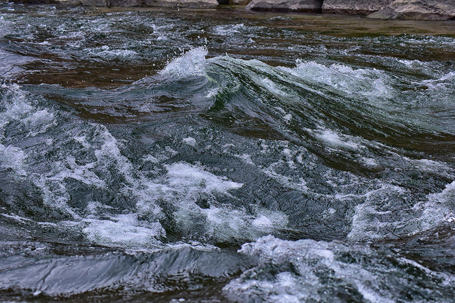 Choppy green Colorado River water crested with white foam